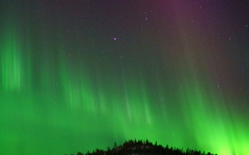 Aurora sobre colinas nevadas na Lapônia