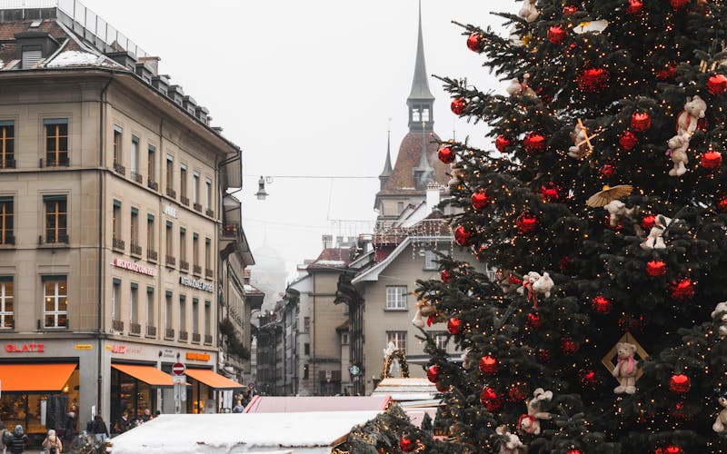 Praça europeia coberta de neve com árvore de Natal